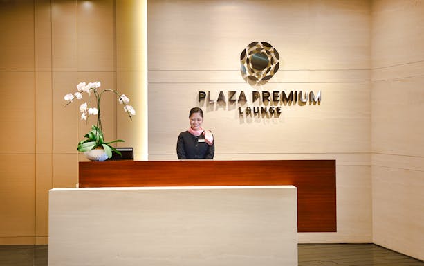 Singapore Plaza Premium Lounge entrance with reception desk and staff.