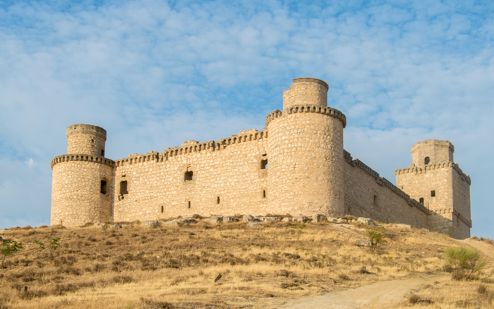 Castillo de Barcience in Spain with stone towers and surrounding countryside.