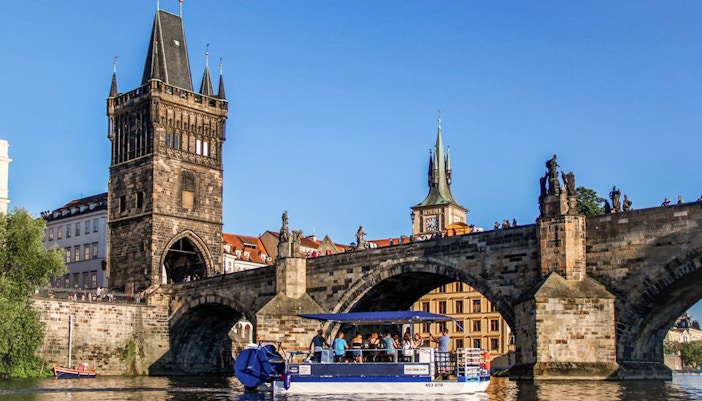 Prague river cruise with tourists enjoying unlimited beer on a scenic boat tour.