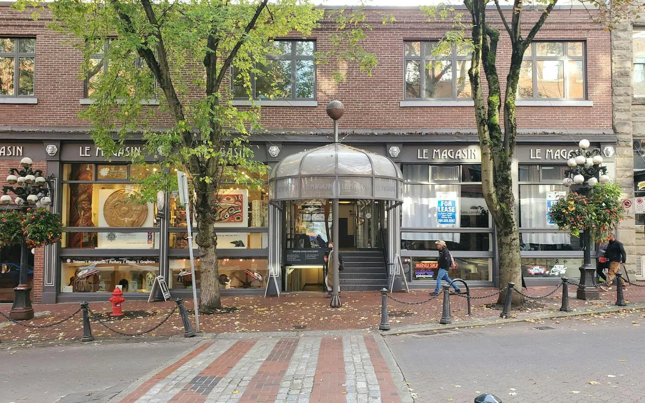 Gastown's Le Magasin building with trees and street view, part of Vancouver exploration game.