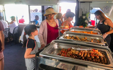 Buffet lunch on Sydney Harbour sightseeing cruise with passengers serving food.