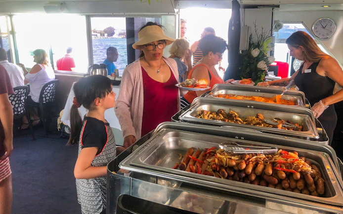 Buffet lunch on Sydney Harbour sightseeing cruise with passengers serving food.