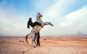 Tourist riding a horse near the Pyramids of Giza in Egypt.