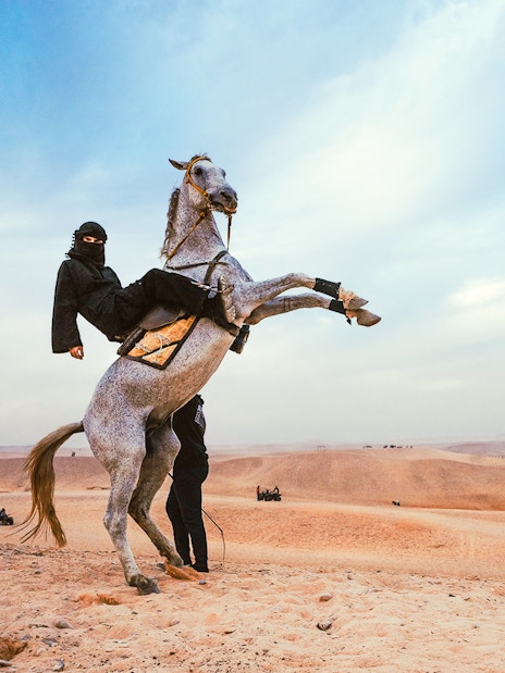 Tourist riding a horse near the Pyramids of Giza in Egypt.