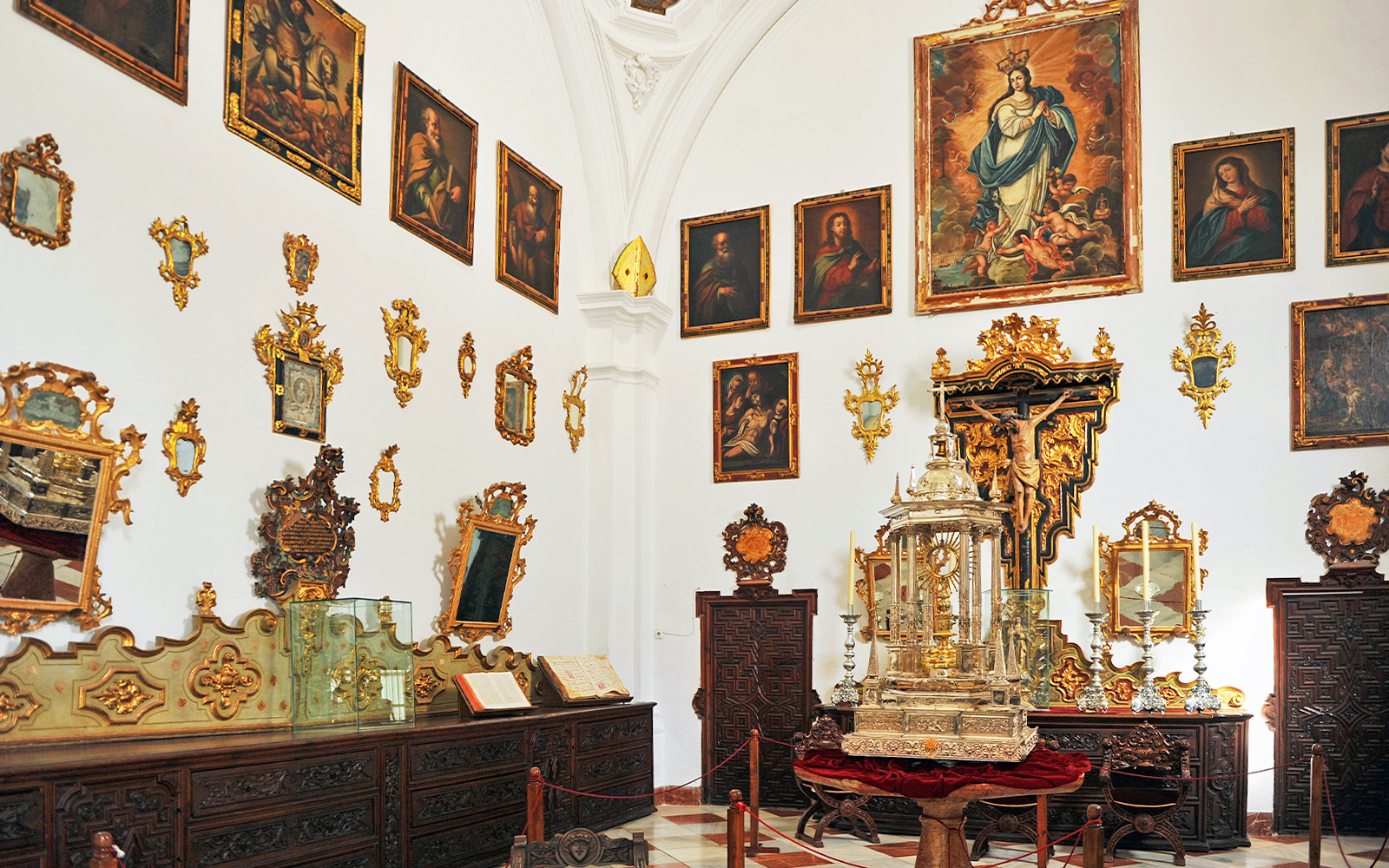 Granada Cathedral Museum interior with religious paintings and ornate artifacts.