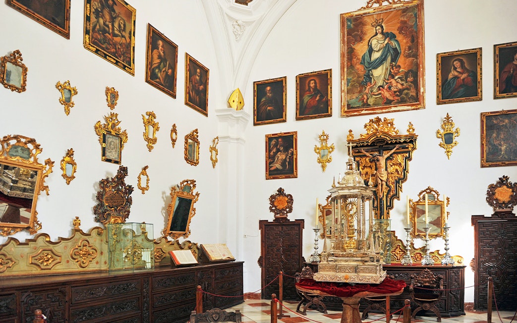 Granada Cathedral Museum interior with religious paintings and ornate artifacts.