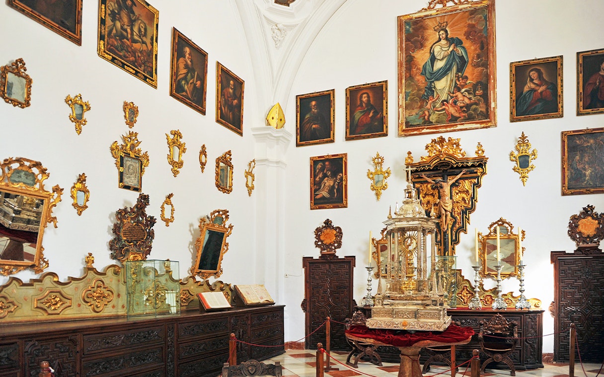 Granada Cathedral Museum interior with religious paintings and ornate artifacts.