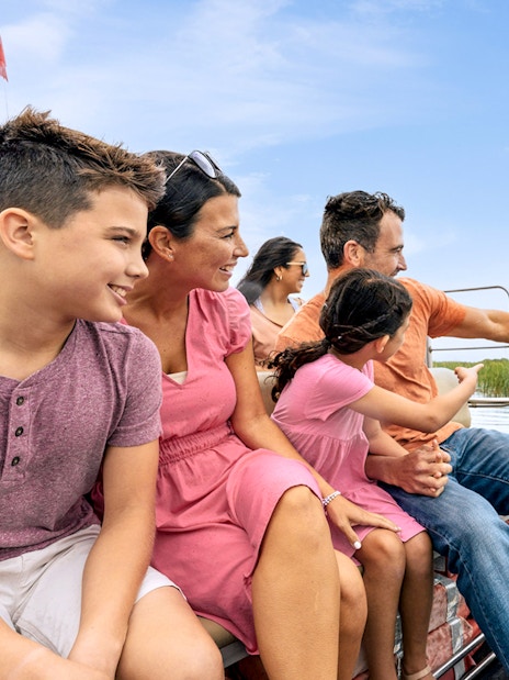 Guests enjoying an airboat tour in the Everglades, surrounded by water and reeds.