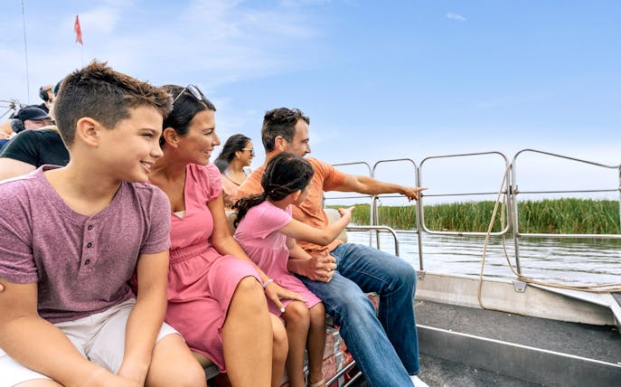 Guests enjoying an airboat tour in the Everglades, surrounded by water and reeds.