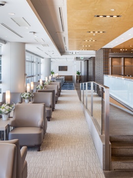 Seating area in Plaza Premium Lounge Nagoya with modern decor and floral arrangements.
