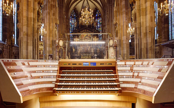 St. Stephen's Cathedral organ console with ornate interior and stained glass windows.