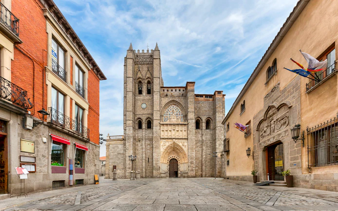 Ávila Cathedral facade with surrounding historic buildings in Ávila, Spain.