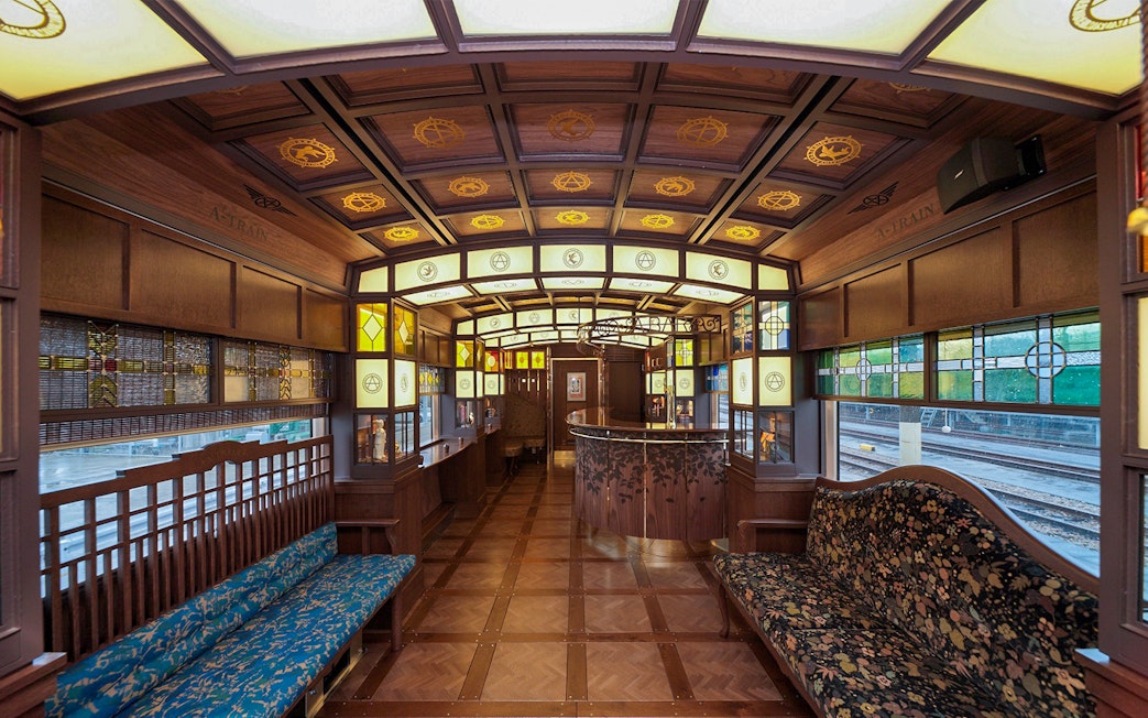 Luxurious interior of a vintage train in Kyushu, Japan, featuring stained glass and wooden decor.