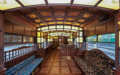 Luxurious interior of a vintage train in Kyushu, Japan, featuring stained glass and wooden decor.