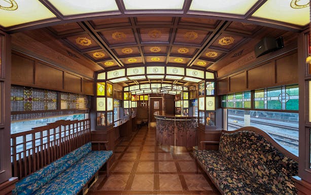 Luxurious interior of a vintage train in Kyushu, Japan, featuring stained glass and wooden decor.