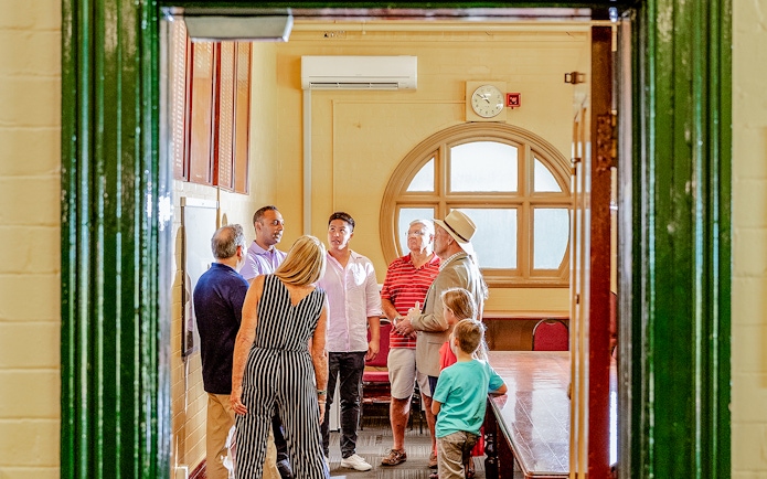 Tour group with guide inside Sydney Cricket Ground meeting room.