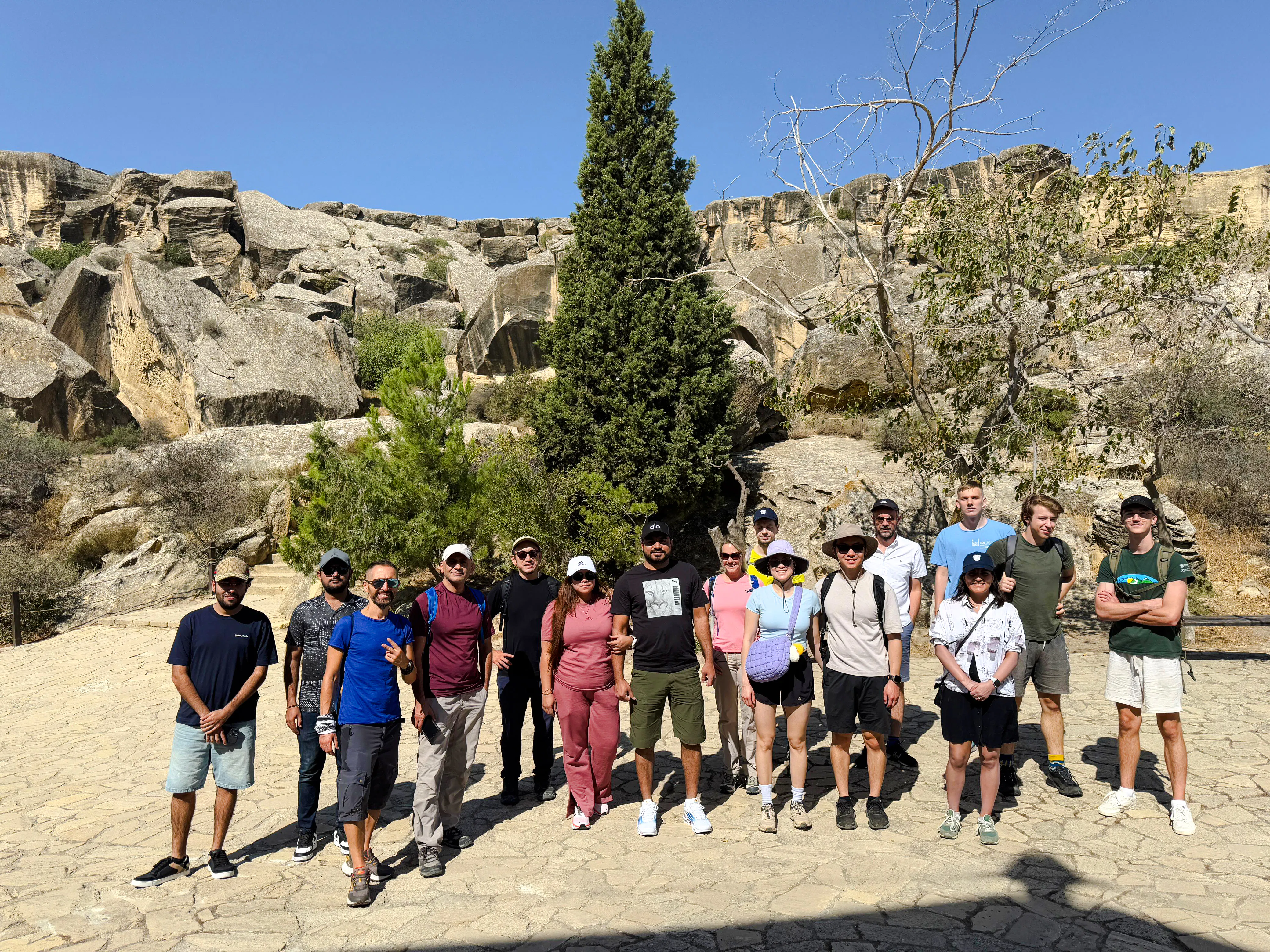 Group of tourists at Gobustan National Park, Baku, with rock formations in the background.