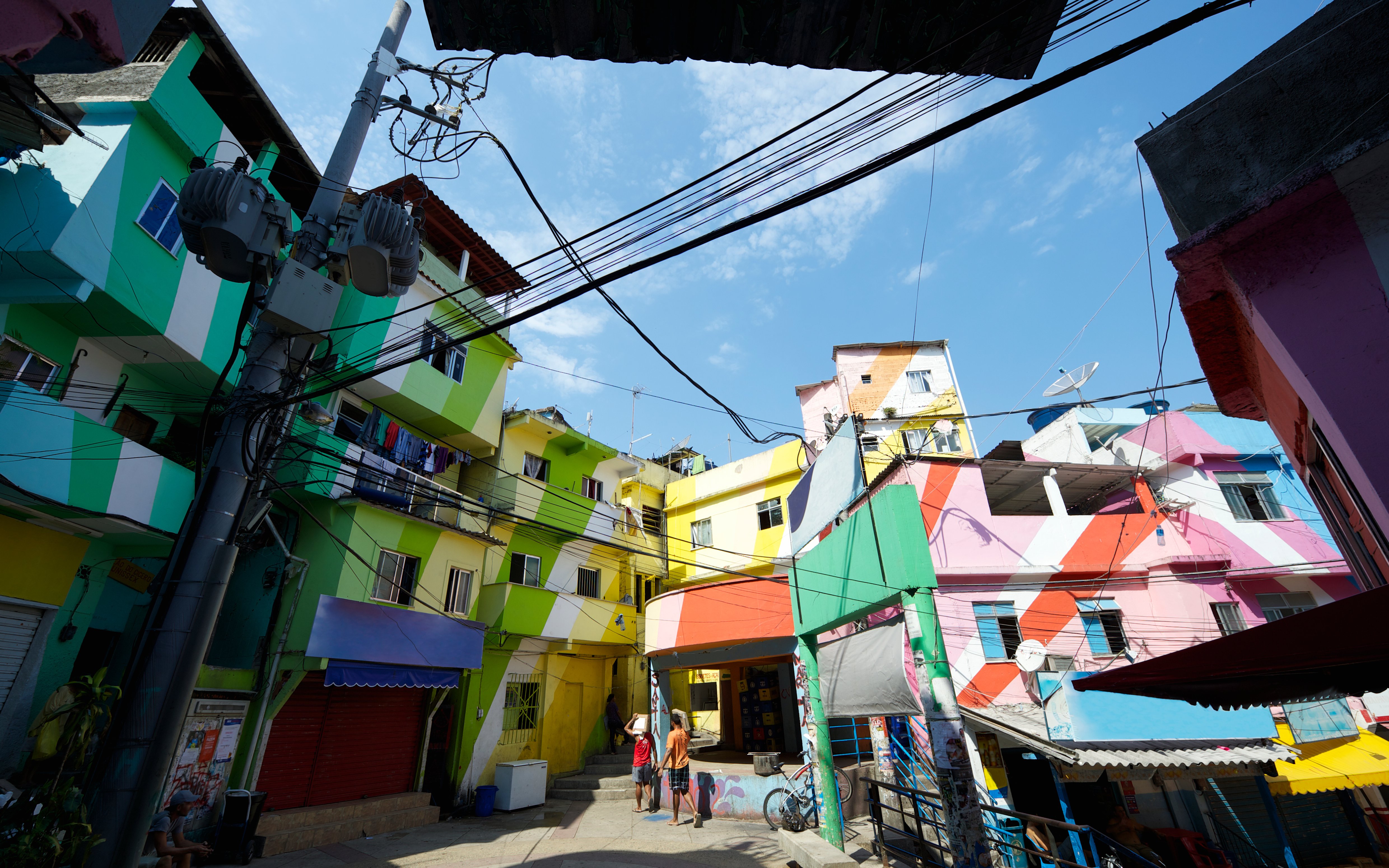 Colorful buildings in Favela Santa Marta, Rio de Janeiro, Brazil, with people walking below.