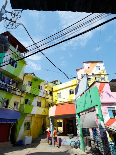 Colorful buildings in Favela Santa Marta, Rio de Janeiro, Brazil, with people walking below.