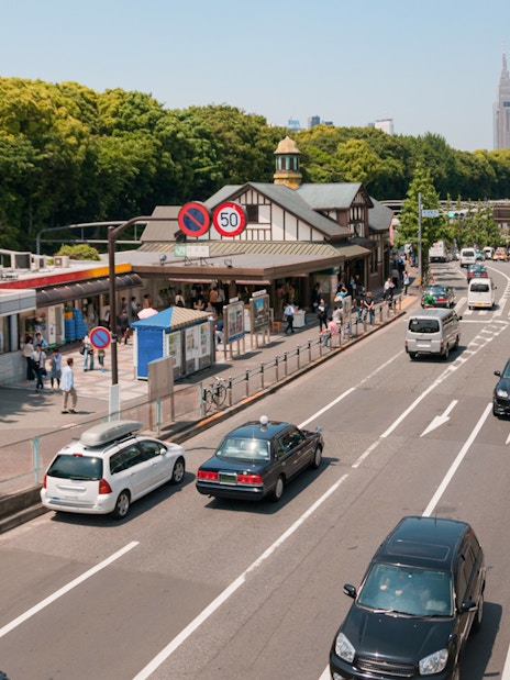 Tokyo street view near Harajuku Station with cars and pedestrians, ideal for Disney Resort transfer.