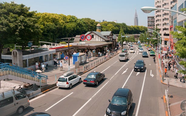 Tokyo street view near Harajuku Station with cars and pedestrians, ideal for Disney Resort transfer.