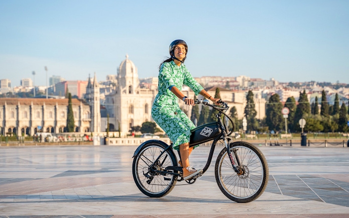 Person riding e-bike near Jerónimos Monastery, Lisbon, on Belém Riverside tour.