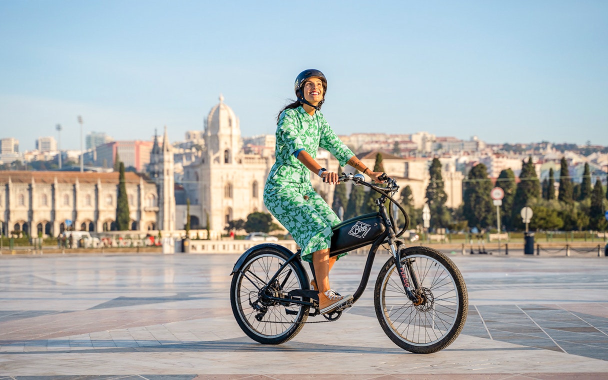 Person riding e-bike near Jerónimos Monastery, Lisbon, on Belém Riverside tour.