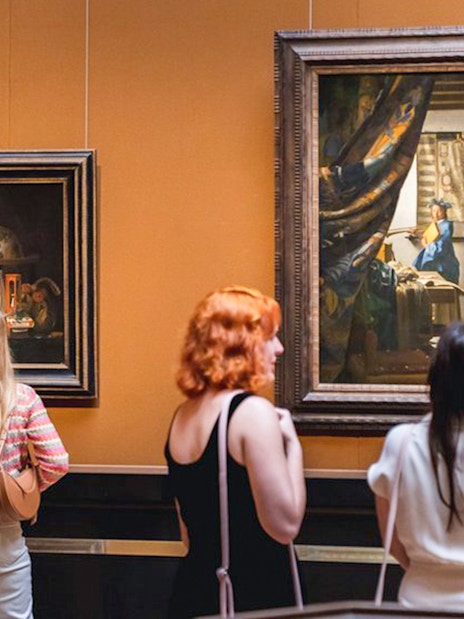 Visitors observing paintings at Kunsthistorisches Museum Vienna.