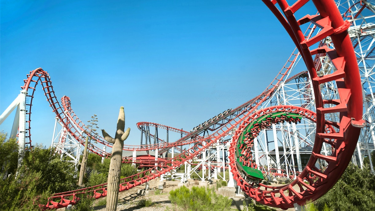 Viper Rollercoaster at Six Flags Magic Mountain with red loops and desert landscape.