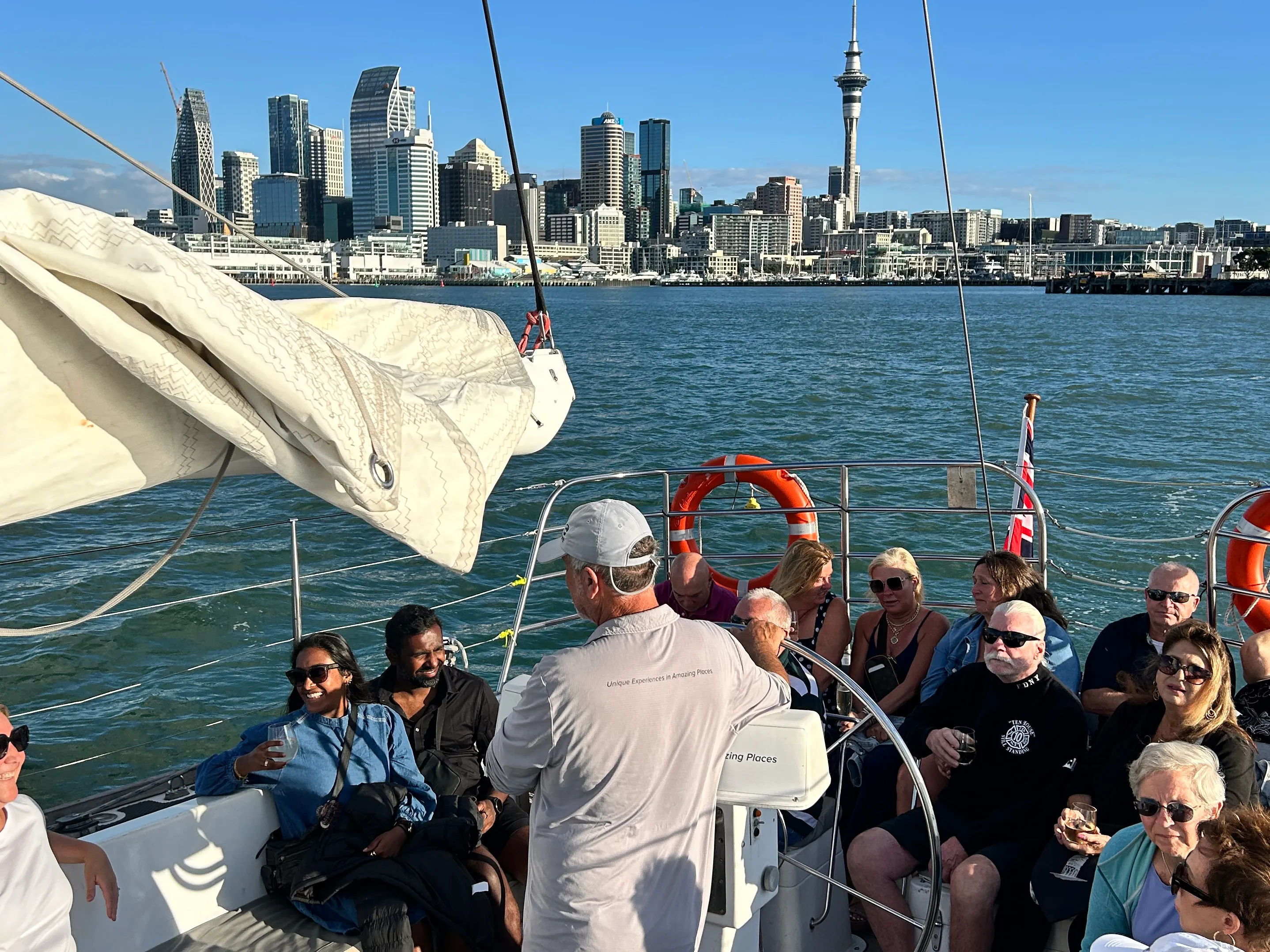 Guests enjoying a 3-course dinner cruise with drinks on Auckland Harbour, city skyline in background.