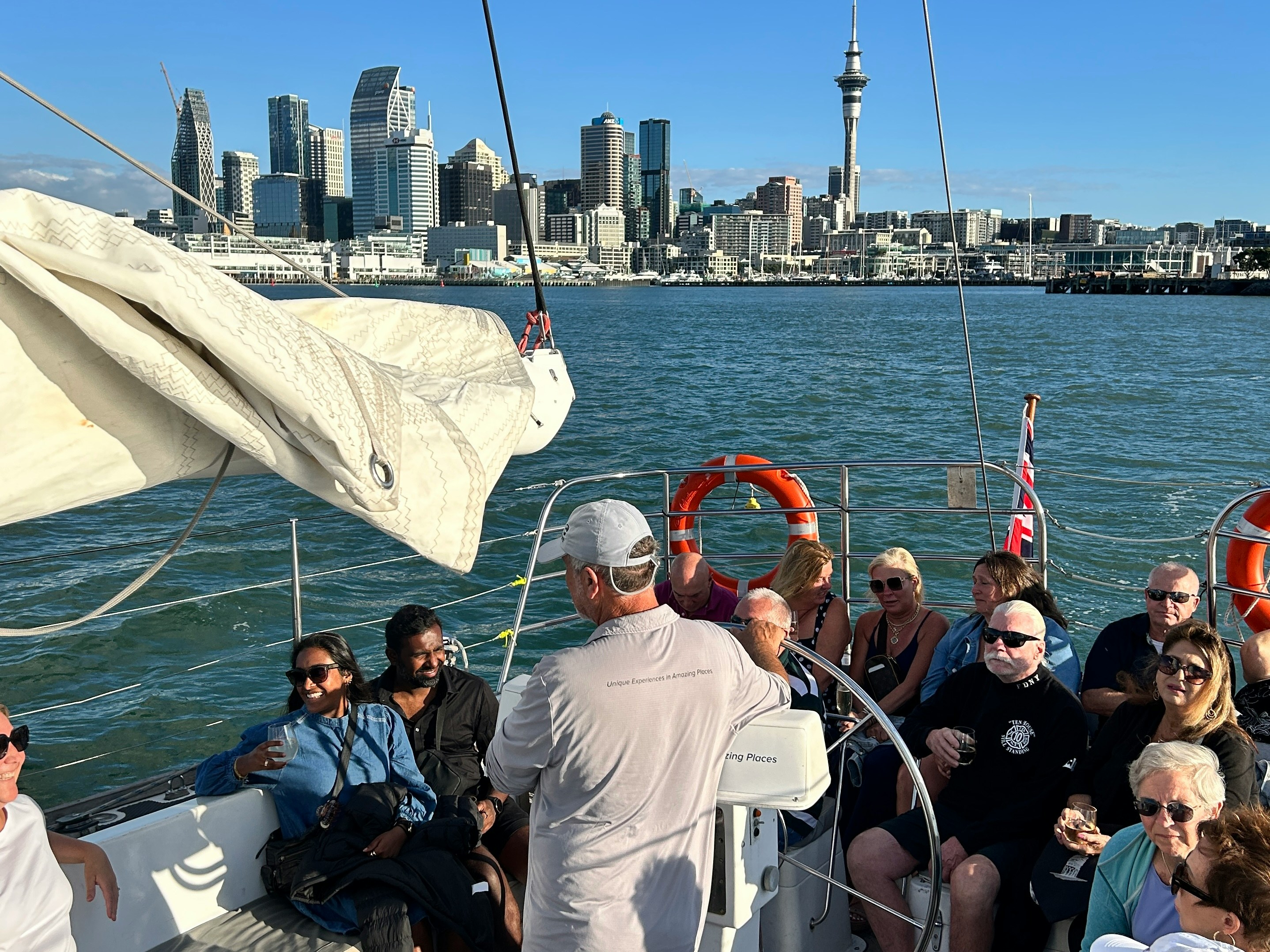 Guests enjoying a 3-course dinner cruise with drinks on Auckland Harbour, city skyline in background.