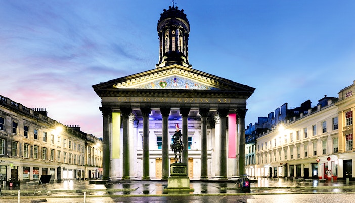 Gallery of Modern Art in Glasgow with equestrian statue at dusk.