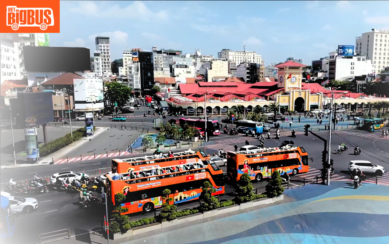Open-top tour buses near Ben Thanh Market, Ho Chi Minh City, on a heritage sightseeing loop.