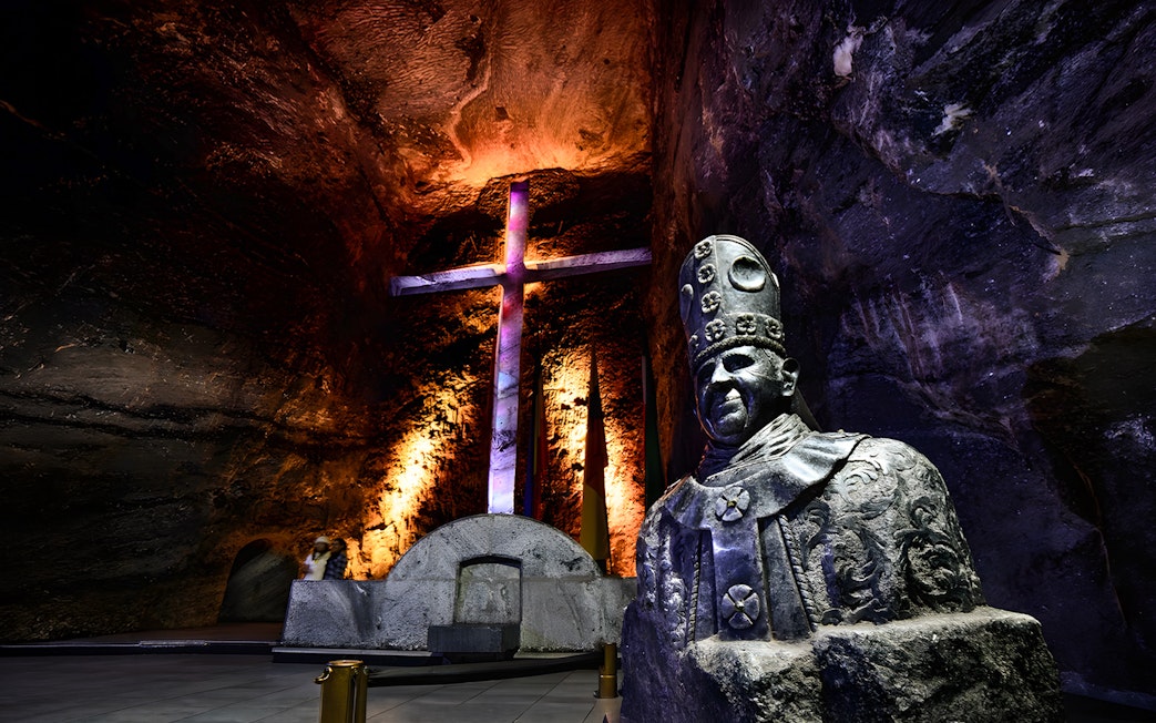 Statue and illuminated cross in the nave of Salt Cathedral of Zipaquirá, Colombia.