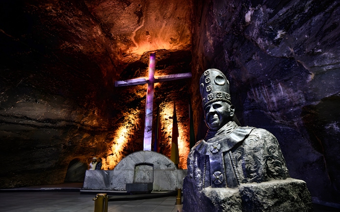 Statue and illuminated cross in the nave of Salt Cathedral of Zipaquirá, Colombia.