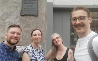 Group of people in front of a historical plaque in Berlin during a self-guided city exploration game.