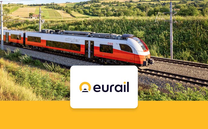 Eurail train traveling through scenic countryside with Eurail logo.