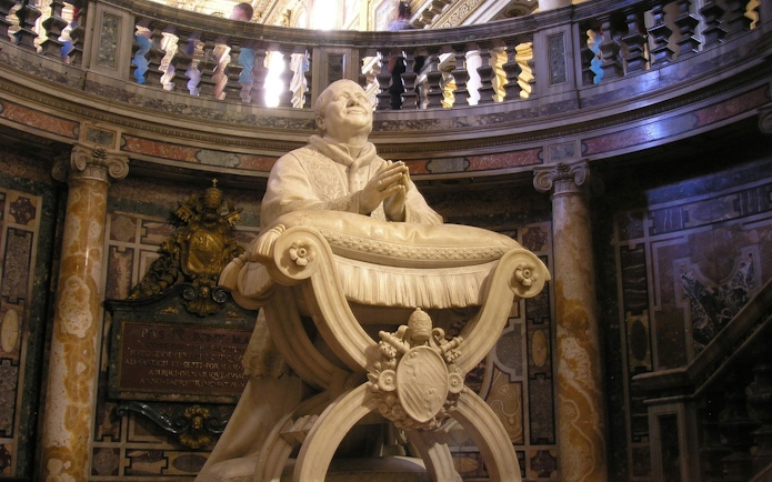Statue of Pope Pius IX by Ignazio Jacometti in ornate interior setting.