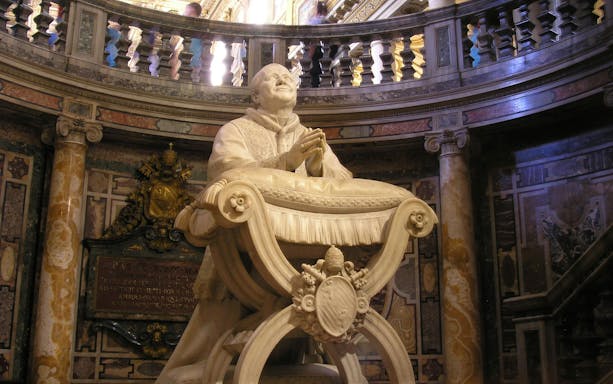 Statue of Pope Pius IX by Ignazio Jacometti in ornate interior setting.