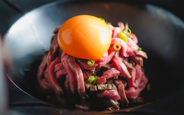 Yakiniku dish with raw egg yolk at Ushihachi Shibuya.