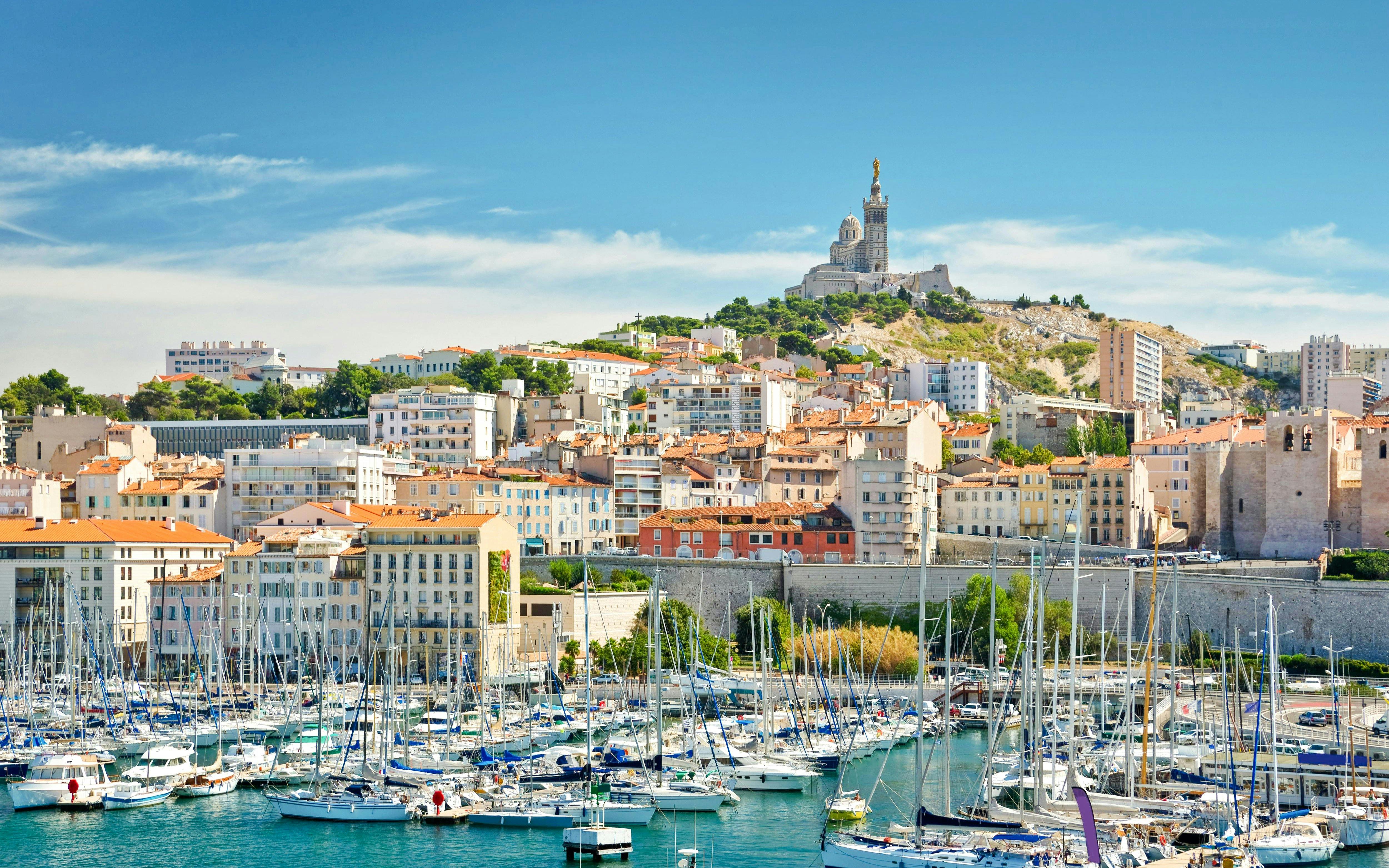 Vieux-Port of Marseille with boats and Notre-Dame de la Garde on the hill.