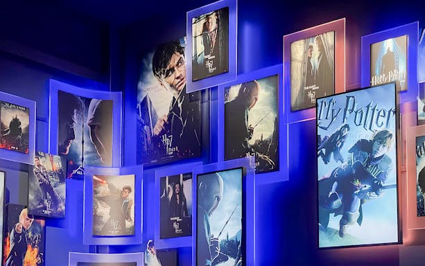 Harry Potter movie posters display at studio tour entrance.