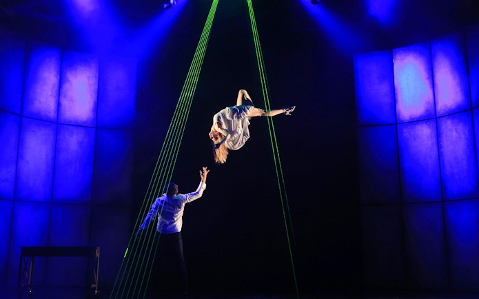 Performer suspended in mid-air during Jamie Allan's Amaze theatre act.