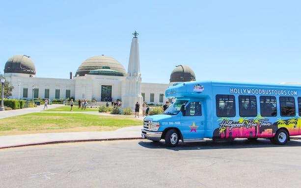 Griffith Observatory in Los Angeles with a Hollywood Bus Tours vehicle in front.