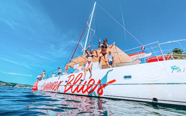 Catamaran cruise with people jumping into the sea near Hvar and Pakleni Islands.
