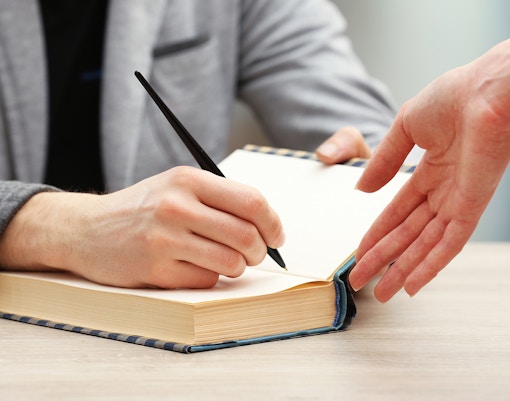 People browsing books at the Festival of Literature in a vibrant outdoor setting.