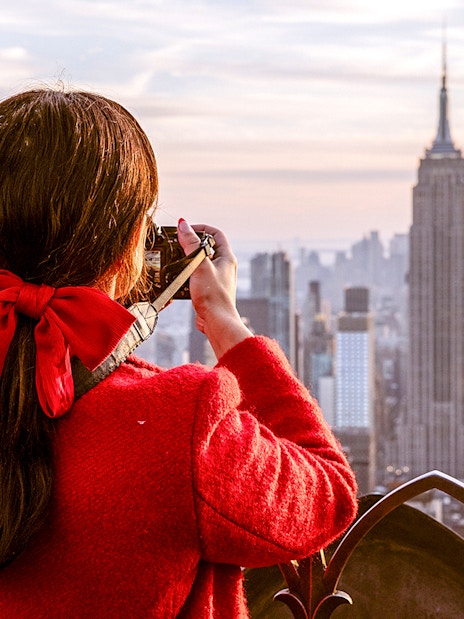 Visitor photographing Empire State Building from Top of the Rock, New York City.