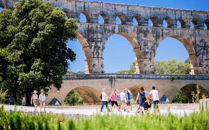 Tourists walking near the Pont du Gard aqueduct in Provence, France.