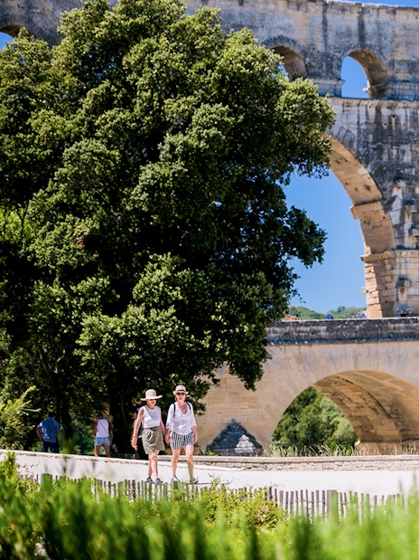 Tourists walking near the Pont du Gard aqueduct in Provence, France.