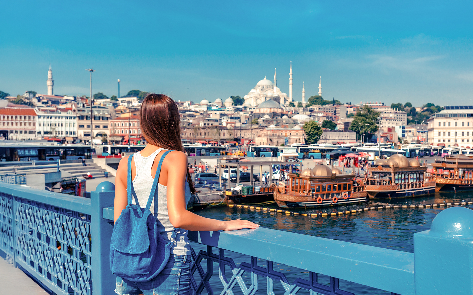 Woman overlooking the Golden Horn from Galata Bridge, Istanbul with Suleymaniye Mosque in view.